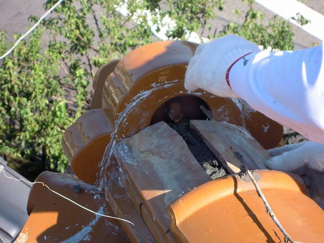 モルタルを詰めながら棟瓦を積む